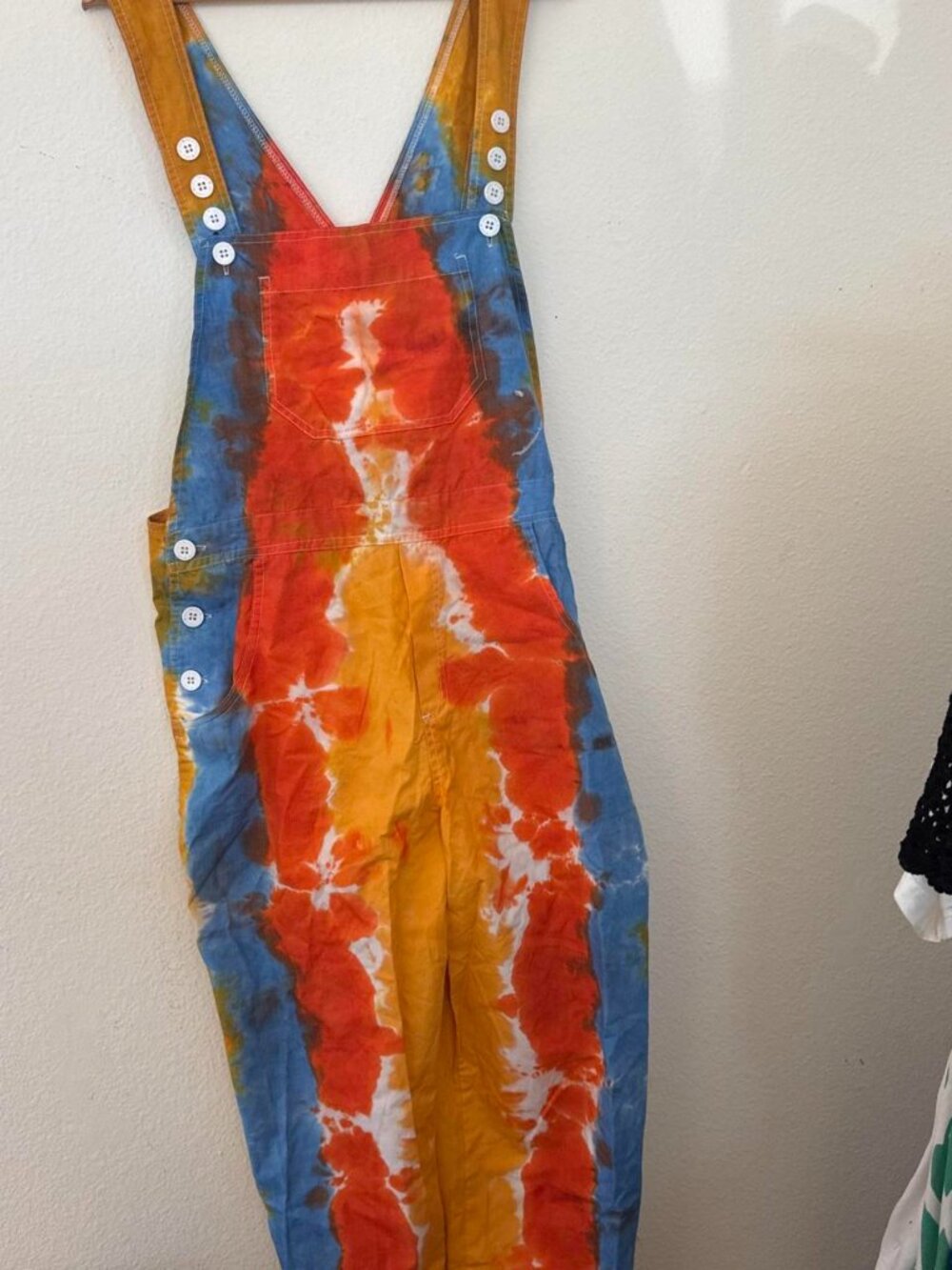 Orange, blue, and white tie-dye overalls in a L